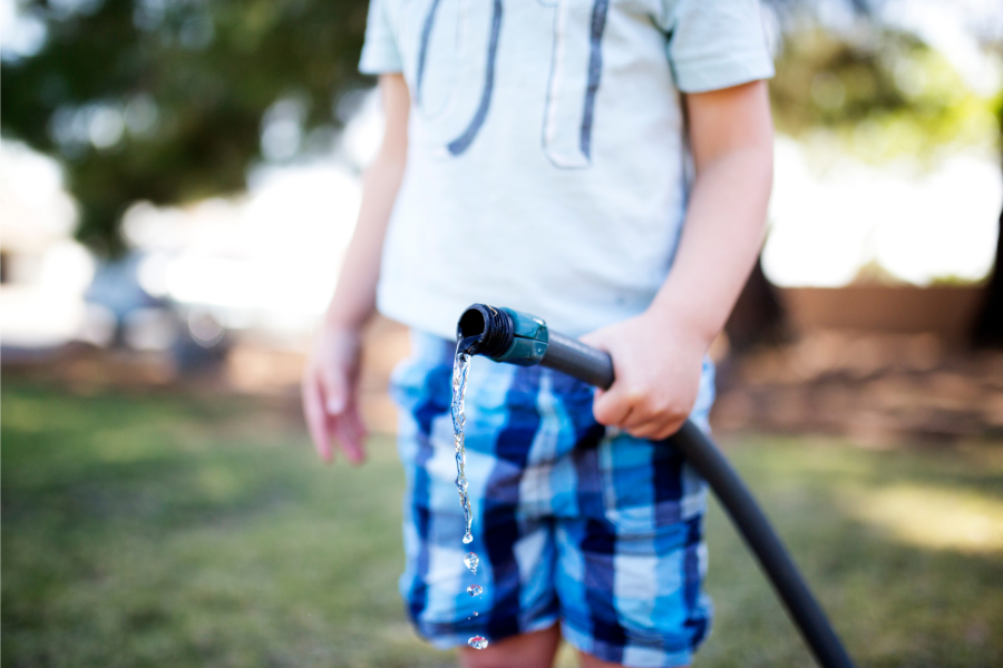 Homeowner using a hose for drip irrigation.