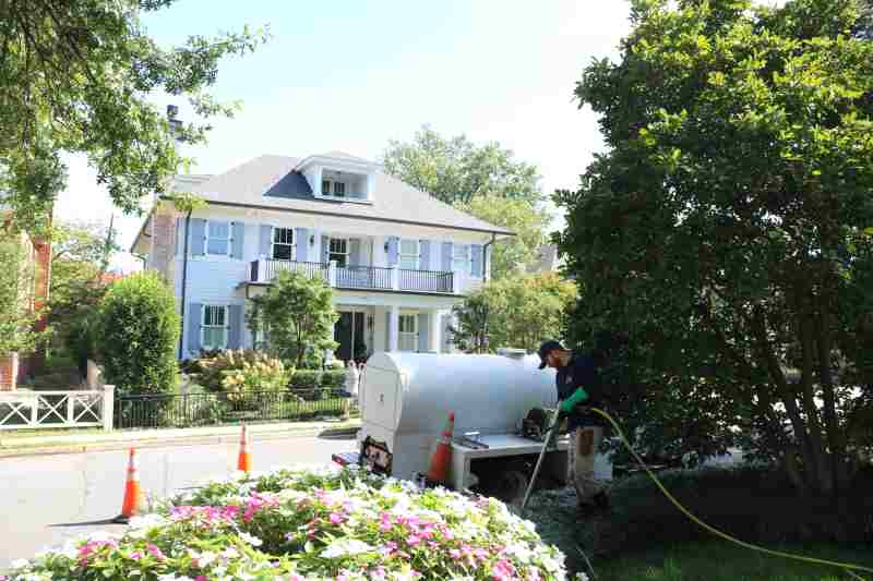rtec employee outside a home working on plants